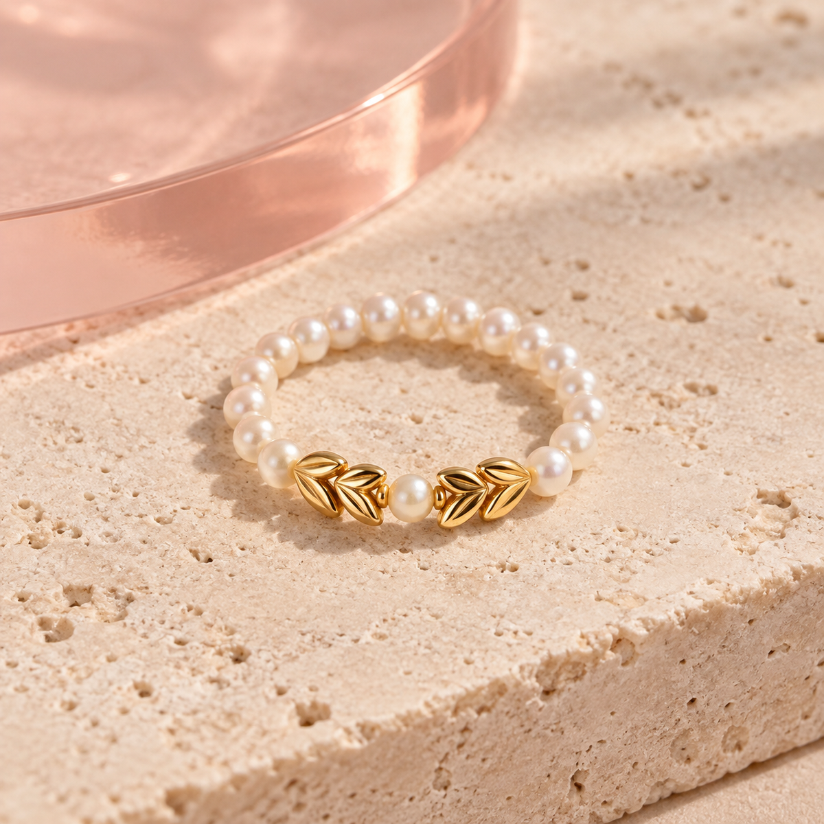 Pearl charm ring with symmetrical polished gold leaves and a center pearl