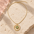 Aurelia Green Orbit Necklace on ivory travertine