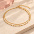 Gold-tone double-layer bead and link anklet on ivory stone