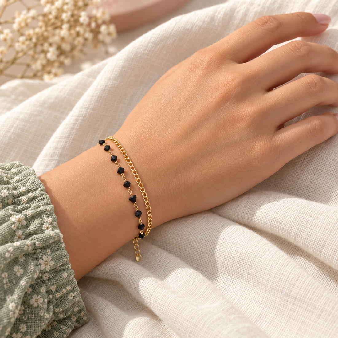 Black bead gold-tone layered bracelet worn on wrist