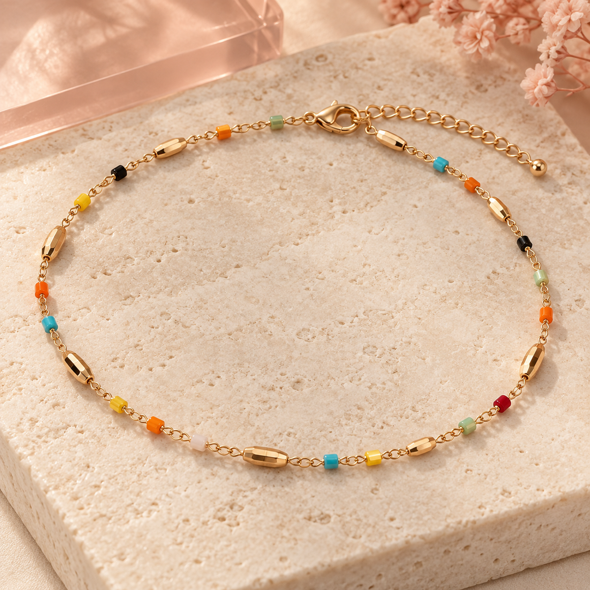 Colorful bead and gold bar single-strand anklet on ivory stone