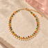 Colorful bead and gold petal anklet on ivory stone