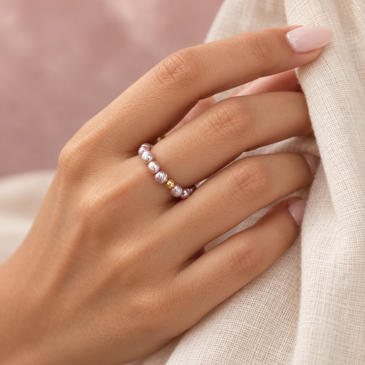 Mauve pearl ring worn on hand