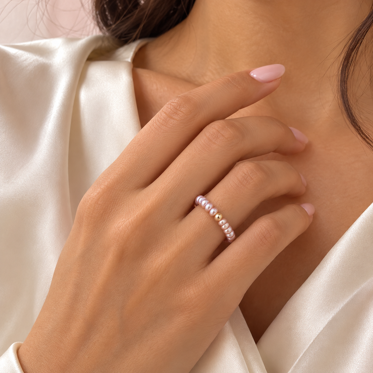 Soft pink pearl ring worn on hand