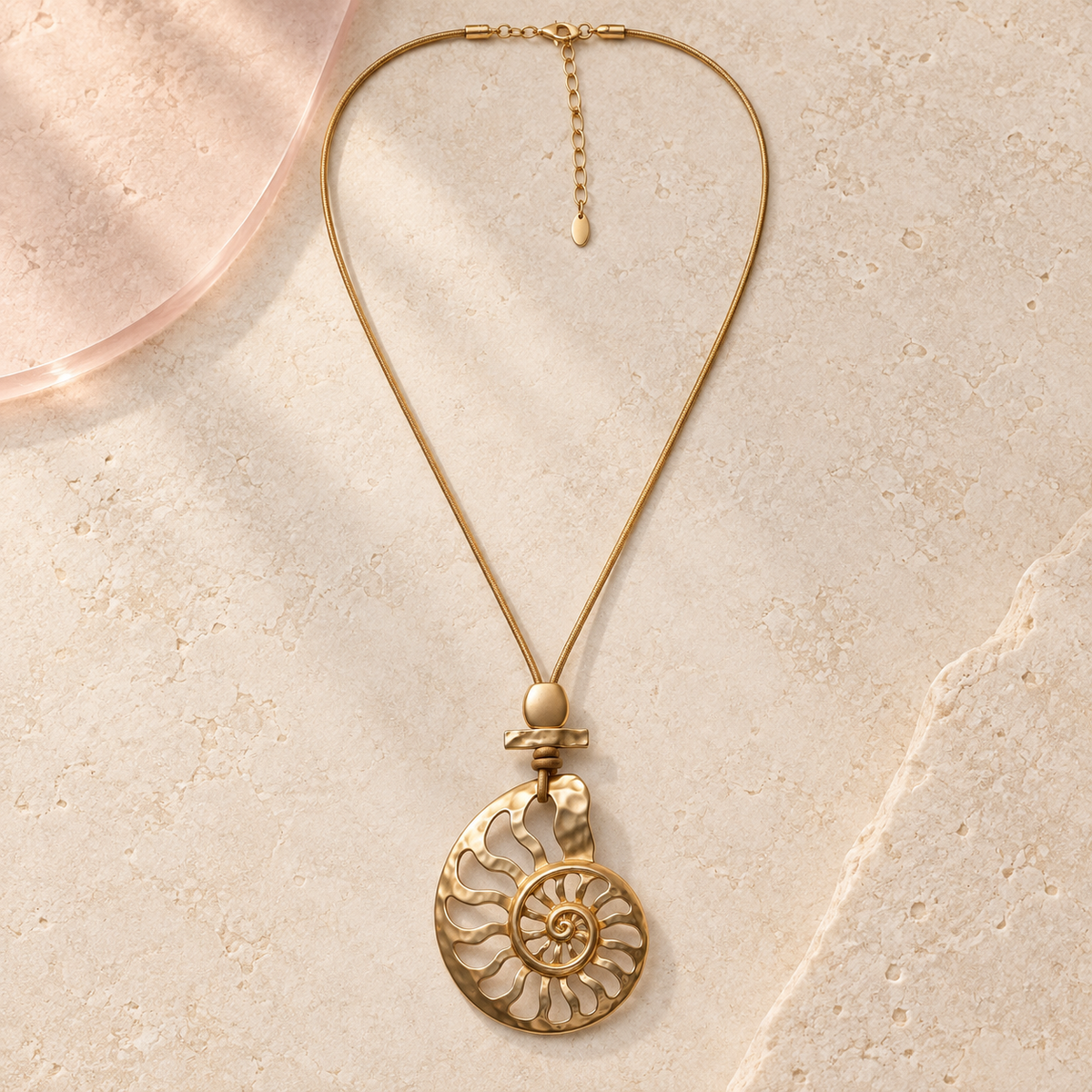 Nerina Spiral Shell Long Gold Necklace on ivory stone