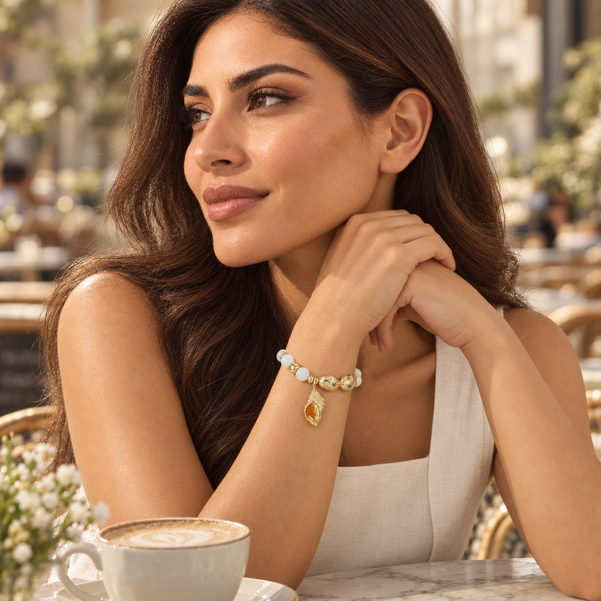 Model wearing Cita Gold Bracelet with ivory outfit
