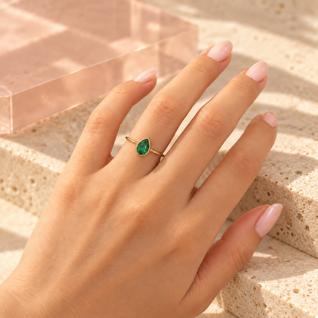 Emerald-green pear-cut crystal ring worn on hand, with Bloomy ivory stone and blush acrylic setting