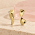 Luna Twist Earrings on Bloomy ivory stone and blush acrylic background