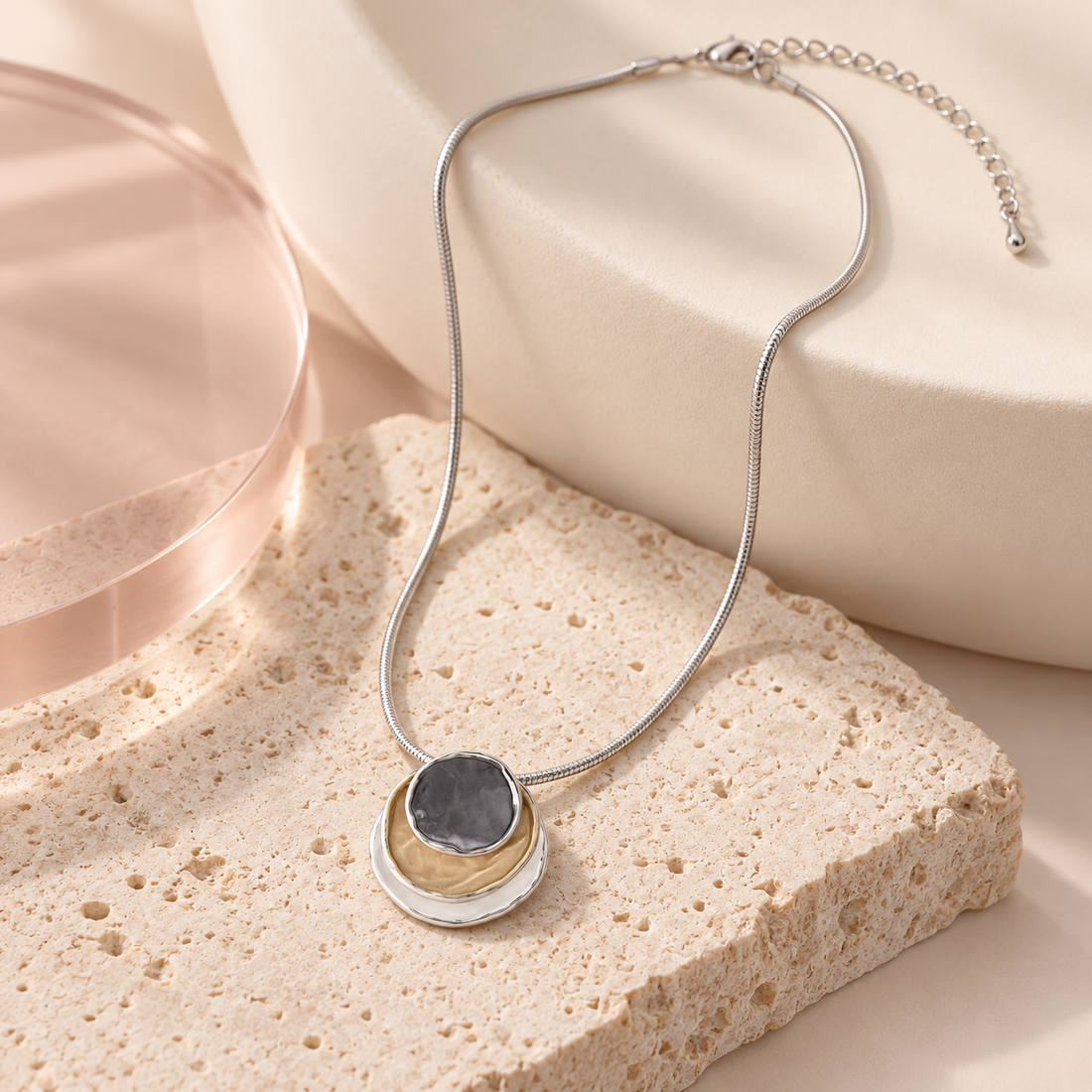 Bloomy Trinity Eclipse Necklace on cream travertine